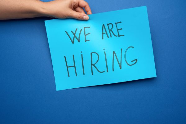 Blue piece of paper with the inscription we are hiring, concept of unemployment Blue piece of paper with the inscription we are hiring, concept of unemployment
